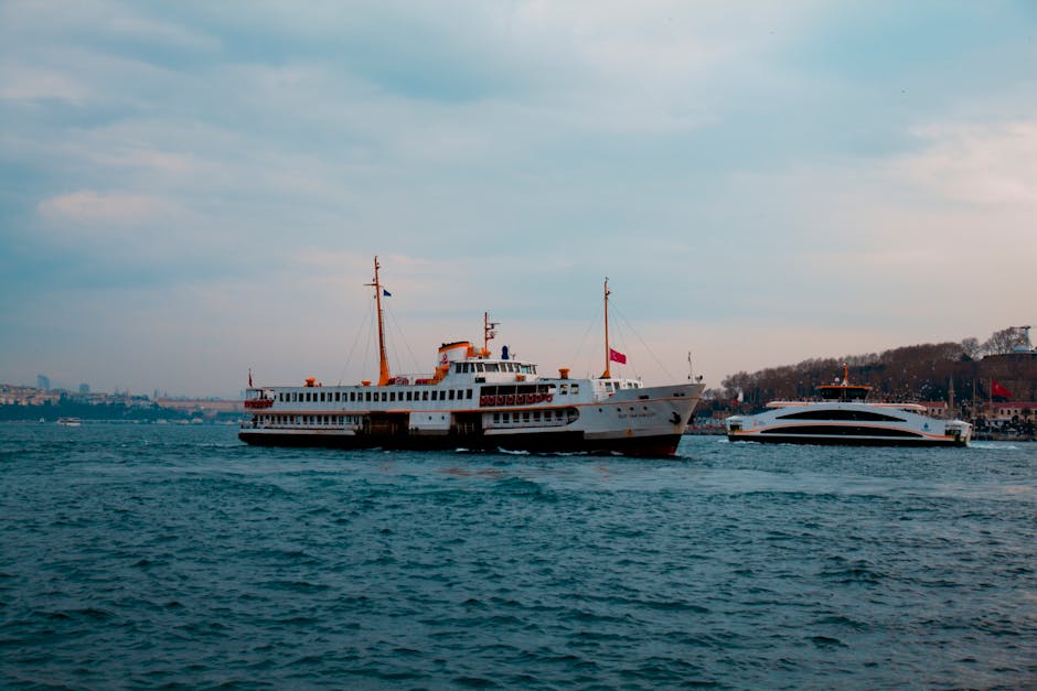 Ferry boat navigating the Bosphorus in İstanbul under a cloudy sky.